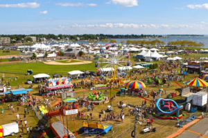 people enjoying thrilling rides, games, and local seafood at the Norwalk Oyster Festival, capturing the excitement of this annual waterfront celebration.