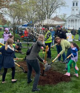 A group of children and adults participate in planting trees as part of the Tree Planting Ceremony