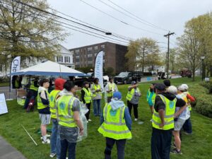Earth Day event staff in neon green vests circle around to kick off the day