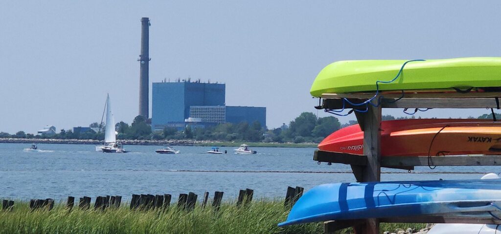 View of boats in the water and kayaks on a stand from Manresa Island. 